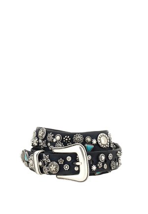 Cintura in pelle nera con borchie argentate floreali e geometriche e una grande fibbia argentata, arrotolata su sfondo bianco.