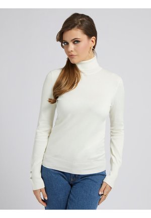 Maglione bianco a collo alto realizzato in un materiale morbido, con maniche lunghe e dettagli con bottoni, dalla vestibilità aderente, abbinato a jeans in denim blu.