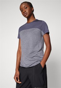 Szara koszulka z krótkim rękawem z granatowym teksturowanym górnym panelem, wykonana z miękkiego materiału. Posiada klasyczny okrągły dekolt i luźny krój.