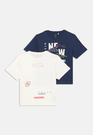 Conjunto de T-shirts: uma branca com texto e gráficos geométricos, e uma azul-marinho com texto em negrito, ambas em algodão. Mangas curtas, gola redonda.