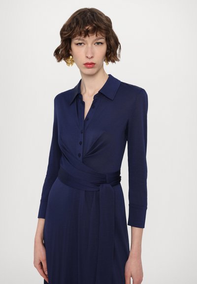 Mornarsko plava haljina na preklop od mekog tkanina s ovratnikom, prednjim gumbima i dugim rukavima s detaljem šnole oko struka za učvršćeni kroj.