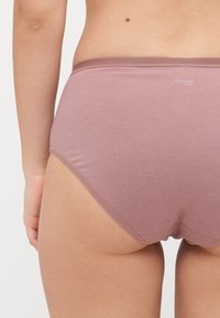 High-waisted, light mauve cotton briefs with smooth texture and elastic waistband, featuring a small logo near the top.