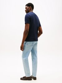 Navy blue short-sleeve t-shirt, plain design, fitted shape; paired with light blue jeans and dark brown loafers.