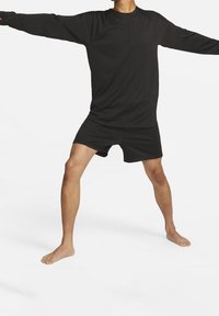 Zwarte lange mouwen top en shorts gemaakt van lichtgewicht stof. De top heeft een ronde hals, en beide stukken hebben een textuurdesign.