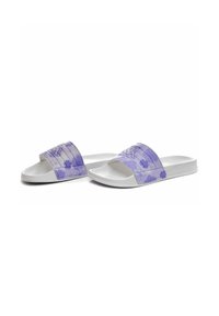 Sandalias de tipo slip-on en púrpura con una correa floral texturizada, suelas blancas y diseño de punta abierta. La correa presenta patrones de flores grabados.