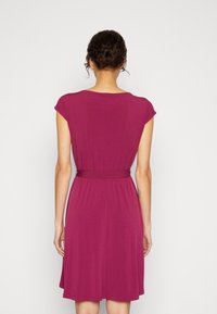 Sukienka z krótkimi rękawami w głębokim różu, z paskiem w talii, swobodnie opadającą spódnicą w kształcie litery A oraz miękkim, gładkim materiałem o minimalnym rozciąganiu.