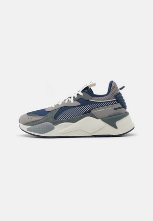 Scarpe sportive caratterizzate da un mix di blu navy, grigio e bianco. I materiali includono rete e camoscio, con una suola testurizzata e accenti a righe.