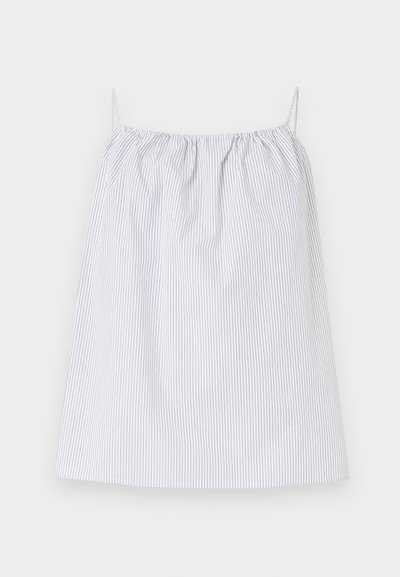 Λευκό αμάνικο τοπ με λεπτές κάθετες μαύρες ρίγες και στρογγυλή γραμμή λαιμού με λεπτές τιράντες σε ανοιχτό φόντο.