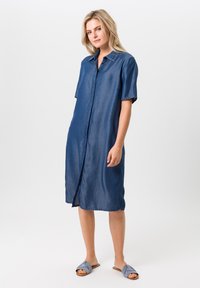 Denim overhemdjurk met korte mouwen, een knoopsluiting aan de voorkant en een knielange snit. Kenmerkt zich door een donkerblauwe tint en een ruime pasvorm.