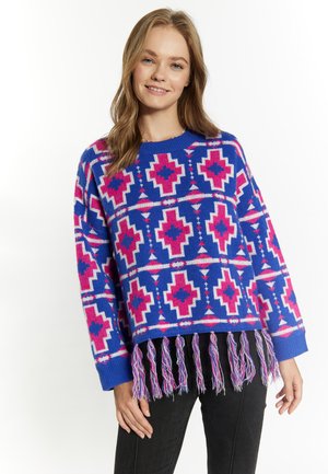 Gebreide trui in het blauw met een roze geometrisch patroon, met een franjezoom en geribde manchetten. Het materiaal lijkt zacht te zijn met een comfortabele textuur.