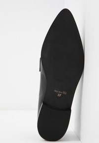 Chaussure noire pour femme avec un bout pointu et une finition lisse, dotée d'un talon mince et d'une semelle en caoutchouc. Taille 37 estampillée sur la semelle intérieure.