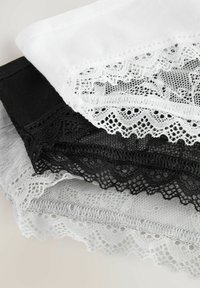 Drie paren shorts met kantontwerpen in zwart, wit en grijs. Elk met delicate kantpatronen langs de randen en een elastische tailleband.