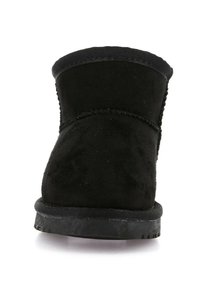 Stivale alla caviglia in suede nero con punta rotonda, caratterizzato da una superficie testurizzata e una suola in gomma nera. Design minimalista con un dettaglio di cucitura.
