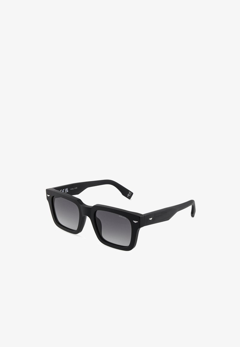 Lunettes de soleil noires à monture carrée avec verres dégradés foncés et accents métalliques subtils sur les coins avant et les branches.