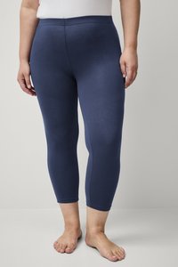 Marineblauwe legging van rekbaar materiaal, met een hoge tailleband en een nauwsluitend ontwerp dat net onder de knie eindigt. Gladde textuur.