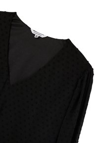 Blusa nera con scollatura a V, tessuto testurizzato con piccoli punti in rilievo, maniche lunghe e un'etichetta che indica la taglia 2XL.