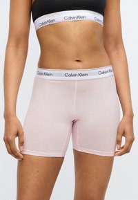 Ροζ βαμβακερά μποξεράκια με λευκή ζώνη μέσης που φέρει τη λέξη «Calvin Klein» σε μαύρα γράμματα. Ομαλή υφή, εφαρμοστό σχέδιο.