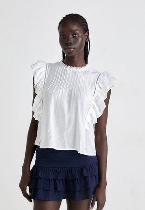 White blouse with ruffled sleeves, featuring a pleated front and lace collar. Worn with a navy layered ruffle skirt.