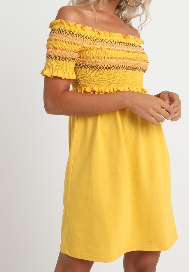 Žluté šaty bez ramínek s volánkovými rukávy, texturovaným smockováním a volným střihem, s horizontálními pruhy v oranžové a černé barvě.
