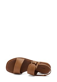 Sandal in pelle marrone con due cinturini larghi, fibbia regolabile e soletta imbottita; suola piatta; design minimalista.