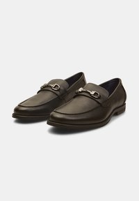 Schwarze Lederloafer mit strukturiertem Finish, ausgestattet mit einer dekorativen Metallschnalle über dem Vorderteil und einem niedrigen, stabilen Absatz.