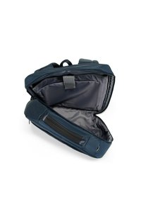 Donkerblauwe rugzak met een gestructureerde buitenkant, ritssluiting en een ruime, grijs gevoerde binnenkant met een insteekvak.