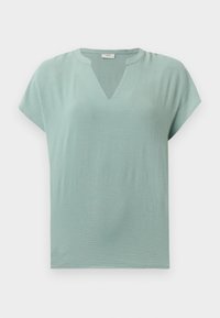 Blouse manches courtes vert clair en tissu texturé avec une petite encoche en V au niveau de l'encolure ronde sur fond uni.