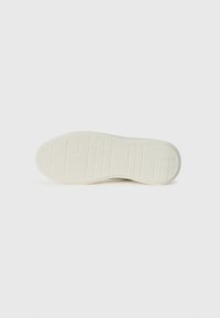 Schuhsohle aus cremefarbenem Gummi mit einer strukturierten, gemusterten Oberfläche. Verfügt über gitterartige und lineare Vertiefungen für Traktion.