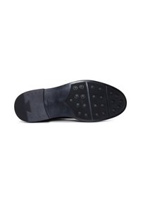 Suola di scarpa in gomma nera con una superficie liscia, motivi di presa circolari e un accento a zigzag vicino al tallone per una maggiore adesione.