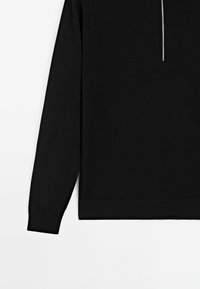 Zwarte pullover met hoge kraag, voorzien van een zilveren rits. Gemaakt van een gladde, textuurrijke stof. Geribbelde manchetten en zoom.