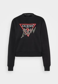 Sudadera negra corta de algodón, con un triángulo rojo que lleva el logo "GUESS" y "ICON" en escritura plateada. Puños y dobladillo ribeteados.