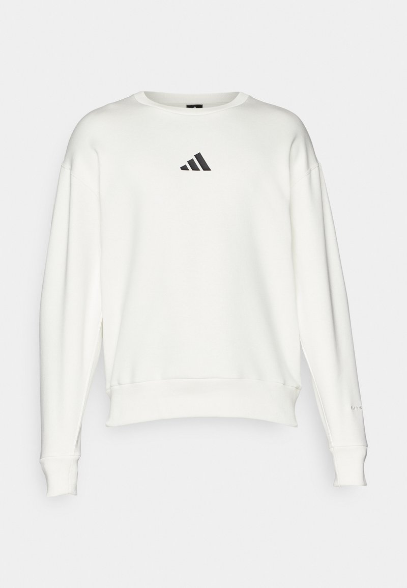 Sudadera blanca de algodón, con cuello redondo, puños anchos y un pequeño logo negro de Adidas en el pecho.