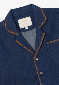 Denim shirt with a dark blue color, contrasting orange stitching, point collar, button closure, and a single chest pocket.