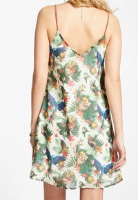 Ärmelloses Kleid mit einem lebhaften tropischen Muster, das mehrfarbige Vögel und Blumen zeigt. Hergestellt aus leichtem Stoff mit einer lockeren Passform.