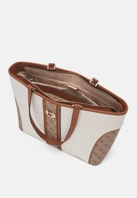 Borsa in tela con accenti in pelle marrone; presenta una chiusura con zip, scomparti interni e un dettaglio del logo in tonalità oro.