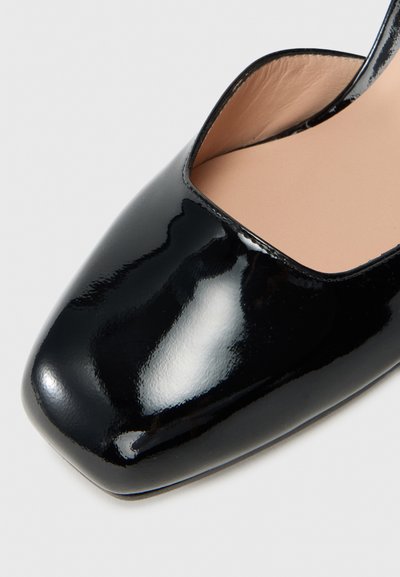 Sapato em verniz preto brilhante com bico quadrado e forro interior na cor nude.