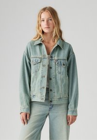 Lichtblauwe denimjack met een relaxte pasvorm, knoopsluiting, twee borstzakken en zichtbare stikseldetails. Heeft een klassiek kraagontwerp.