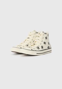 Hochgeschnittene Canvas-Sneaker in Creme mit schwarzen grafischen Mustern. Verfügt über Metallschnürösen und eine Gummisohle mit einem schwarzen Streifen.