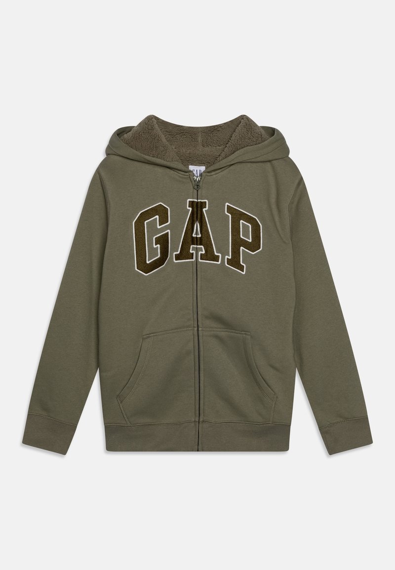Veste à capuche zippée vert olive avec doublure en polaire, poches avant et grandes lettres "GAP" marron foncé avec contour blanc sur la poitrine.