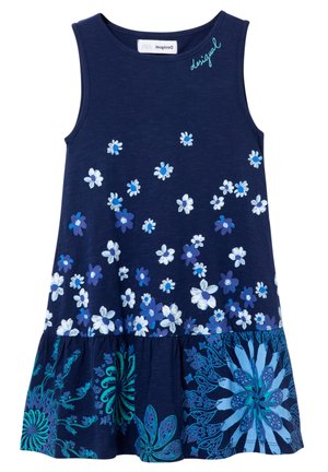 Marineblå ærmeløs kjole med spredte hvide og blå blomster, flæsekant med store blomsterprints og "Desigual"-logo nær udskæringen.