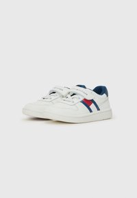 Baskets blanches avec des rayures bleues et rouges, en cuir, avec un système de fermeture à lacets et Velcro, semelle en caoutchouc, et la marque "TOMMY HILFIGER" sur la sangle.