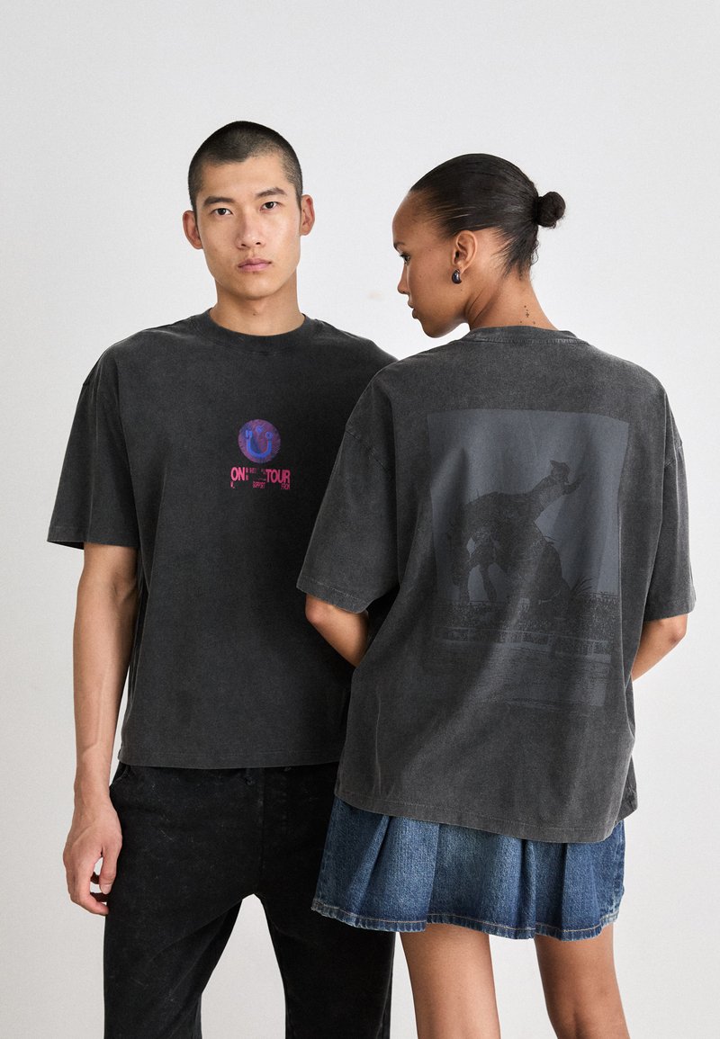 Oversized gray cotton T-shirts feature a front graphic with a circle design and back print of two elephants in a dark wash finish.