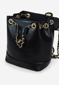 Bolso tipo cubo de cuero negro con herrajes dorados, detalles de cadena y un lazo. Presenta una textura suave y un diseño de apertura en la parte superior.