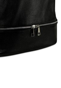 Sac en simili cuir noir texturé avec une fermeture éclair argentée en bas, mettant en avant une finition lisse et une forme structurée.