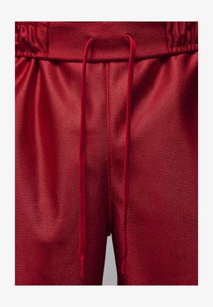 Punased sportlikud lühikesed püksid tekstureeritud, soonilise kangaga, varustatud elastse vöökoha ja reguleeritava paelaga.