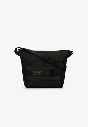 Schwarze Crossbody-Tasche mit verstellbarem Riemen, Frontschnallendetail und "WITTCHEN" Logo-Patch auf dem textilen Körper.