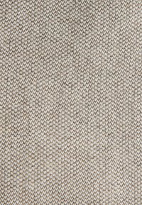 Tejido texturizado en tonos de beige y marrón claro, con un tejido apretado y pequeños patrones uniformes, lo que da como resultado una superficie suave y resistente.