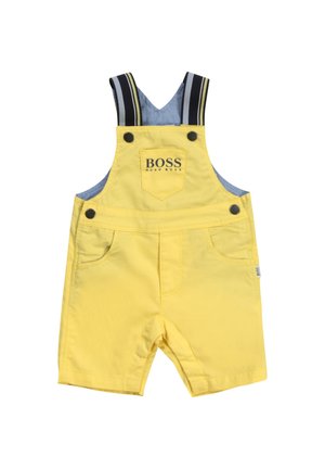Gelbe kurze Latzhose für Kleinkinder mit gestreiften, verstellbaren Schultergurten und einer Vorderstasche mit der Aufschrift "BOSS HUGO BOSS".