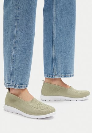 Hellgrüne Slip-On-Schuhe aus atmungsaktivem Mesh. Verfügen über einen strukturierten Oberstoff mit perforiertem Design und eine kontrastierende weiße Sohle.