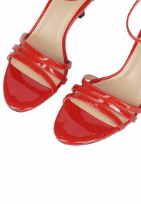 Sandali a tacco alto in vernice rossa con punta affusolata e tre fasce eleganti nella parte anteriore. Suola nera opaca.